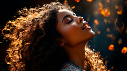 Wall Mural - young woman with curly wavy hair in a dark room