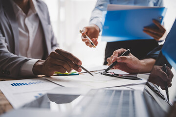 Wall Mural - Young colleagues discussing business and price chart analyzes business people on the table great in modern coworking office teamwork concept. Calculate personal tax for customers