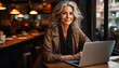 © Crowded Studio - Una elegante persona mayor mujer de negocios trabaja en una computadora portátil desde la oficina en casa.Freelance de edad avanzada se sienta en la mesa de la sala de estar. Ia generado.