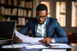 © AI_images - Busy young African American business man bank account manager sitting at office.