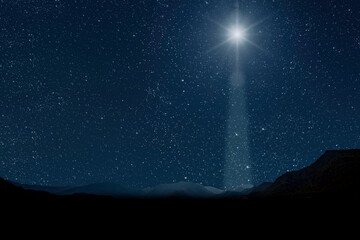 Wall Mural - A christmas star shines at night over the mountains of Bethlehem