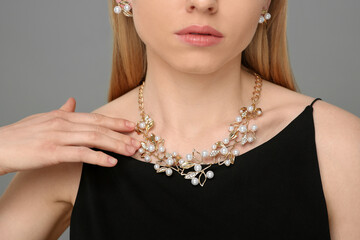 Wall Mural - Woman with elegant jewelry on gray background, closeup