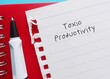 Pencil writing on notebook written  TOXIC PRODUCTIVITY, means desire for productivity at all times, inability to stop working and take adequate time to rest and recharge