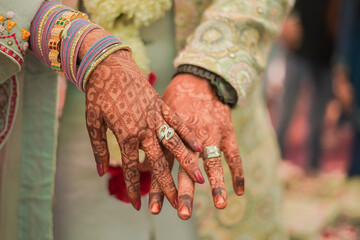 Indian groom and bride hand in hand showing ring