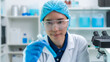 © basiczto - Scientist wearing glassware research in chemistry laboratory for pharmaceutical using beaker and test tube equipment for analysis microbiology