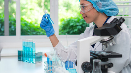 Scientist wearing glassware research in chemistry laboratory for pharmaceutical using beaker and test tube equipment for analysis microbiology