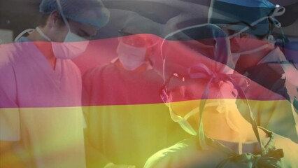 Wall Mural - Animation of waving germany flag against team of diverse surgeons performing operation at hospital