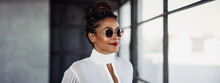 Lifestyle portrait of stylish and attractive black woman standing in urban loft interior