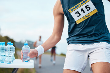 Canvas Print - Hand, water and running a marathon race for competition closeup with fitness or cardio on a street. Sports, exercise or health and a runner or athlete person with a drink while on a road for training