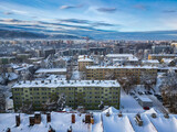 Fototapeta Do pokoju - Budynki i bloki mieszkalne miasta Bielsko-Biała w zimie widoczne z lotu ptaka, w tle góry Beskidu i lekko zachmurzone niebo 