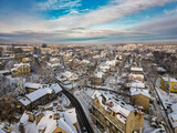 Fototapeta Miasto - Budynki i bloki mieszkalne miasta Bielsko-Biała w zimie widoczne z lotu ptaka, w tle góry Beskidu i lekko zachmurzone niebo 