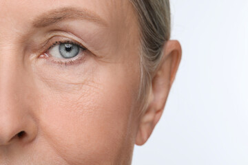 Sticker - Senior woman with aging skin on white background, closeup. Rejuvenation treatment