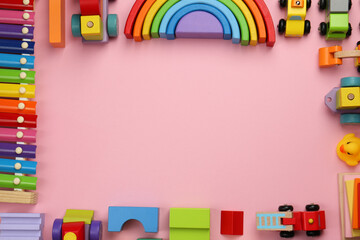 Canvas Print - Frame of different children's toys on pink background, flat lay. Space for text