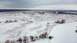 Beautiful snowy and cloudy  flat landscape in the winter. Aerial view of the snowy valley in the winter. Beautiful winter landscape with a blue tint. Beautiful nature