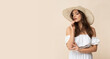 © forma82 - Very beautiful young woman in straw hat and white boho dress on creamy background.