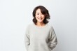 © Robert MEYNER - portrait of a confident Japanese woman in her 40s wearing a cozy sweater against a white background