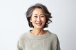 © Robert MEYNER - portrait of a confident Japanese woman in her 50s wearing a cozy sweater against a white background