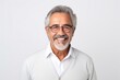 © Leon Waltz - medium shot portrait of a confident Mexican man in his 60s wearing a chic cardigan against a white background