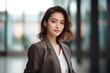 © Leon Waltz - medium shot portrait of a Filipino woman in her 20s wearing a classic blazer against a modern architectural background
