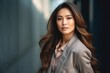 © Leon Waltz - medium shot portrait of a Filipino woman in her 30s wearing a classic blazer against an abstract background