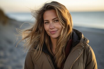 Sticker - Portrait of a Polish woman in her 30s wearing a warm parka against a beach background