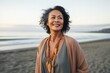 © Leon Waltz - portrait of a happy Filipino woman in her 50s wearing a chic cardigan against a beach background