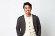 medium shot portrait of a happy Japanese man in his 30s wearing a chic cardigan against a white background
