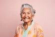 © Anne-Marie Albrecht - medium shot portrait of a 100-year-old elderly Mexican woman wearing a chic cardigan against a pastel or soft colors background