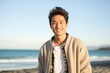 © Leon Waltz - portrait of a Japanese man in his 20s wearing a chic cardigan against a beach background