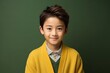 medium shot portrait of a confident Japanese child male wearing a chic cardigan against an abstract background