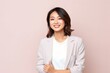 © Anne-Marie Albrecht - medium shot portrait of a confident Japanese woman in her 30s wearing a chic cardigan against a pastel or soft colors background
