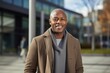 © Anne-Marie Albrecht - medium shot portrait of a confident Kenyan man in his 30s wearing a chic cardigan against a modern architectural background