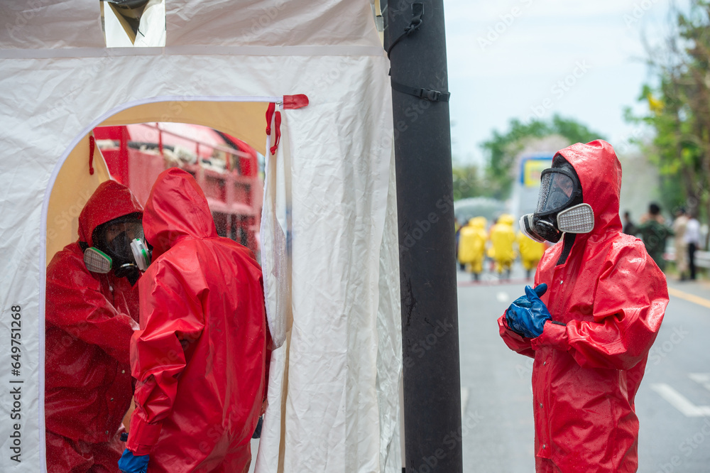 Rescuers wearing red hazmat suits assembled a Inflatable sterilization ...