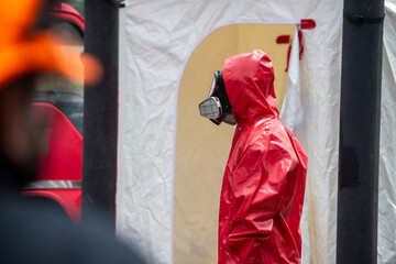 Rescuers wearing red hazmat suits assembled a Inflatable sterilization tunnel tentst. To be used in rescue accidents where toxic substances are leaking.