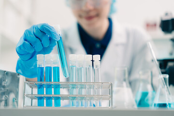 Wall Mural - scientist analyzing and dropping a sample into a glassware, medicine science experiments containing 