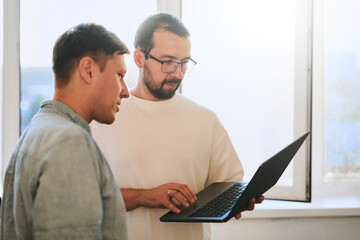 Wall Mural - Portrait of two professional male programmers working on computer in diverse offices. Modern IT technologies, development of artificial intelligence, programs, applications and video games concept