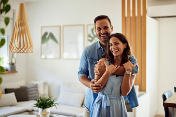 Portrait of an adult couple, husband and wife smiling for the camera, being at home.