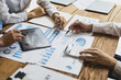 © Wasan - Business meeting, brainstorming sessions discuss analysis of investment growth graph and market charts in financial reports and business investment strategy planning.