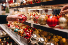 Selective Focus, Hand Are Selecting Souvenir And Colourful Shining Decoration Balls On The Shelf And Box At The Counter Of Stall During Christmas Season. Generative AI. 
