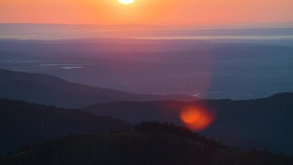 Wall Mural - Amazing mountain landscape. Dark spruce woods illuminated with yellow setting sun. Bright colorful sunset in wild national park highlands