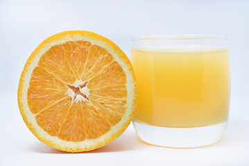 Wall Mural - Orange juice in a glass glass and the fruit of oranges. Refreshing drink on a white background of fruit.