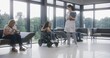 © Framestock - Woman in electric wheelchair waits for consultation with doctor in clinic waiting area. Nurse invites patient with disability on procedures. Medical staff and people in modern medical facility lobby.