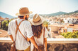 Multiethnic couple traveling in Spain in summer. Happy young travelers exploring in city.