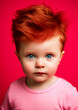 Redhead baby boy in pink clothes on a conceptual pink background for frame