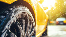 Close Up View Of A Yellow Car Wheel Being Sprayed With Water.