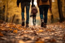 Friends Walking On A Road Full Of Fallen Leaves In Autumn