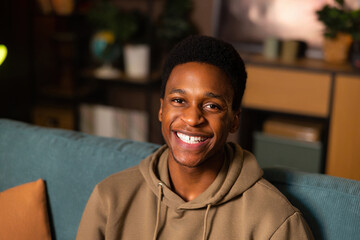 Portrait of beaming smile and infectious joy of an African man who looks directly into the camera welcoming expression invites the viewer in, while his eyes twinkle with happiness and optimism