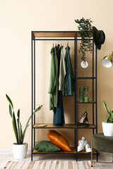 Sticker - Shelving unit with clothes and shoes near beige wall in hall