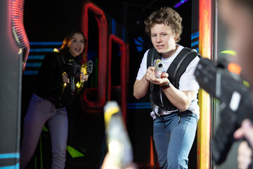 Canvas Print - Portrait of positive young man with laser gun having fun with her friends on lasertag arena