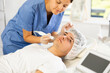 © JackF - Young woman cosmetologist performs facial microcurrent procedure with apparatus young male patient